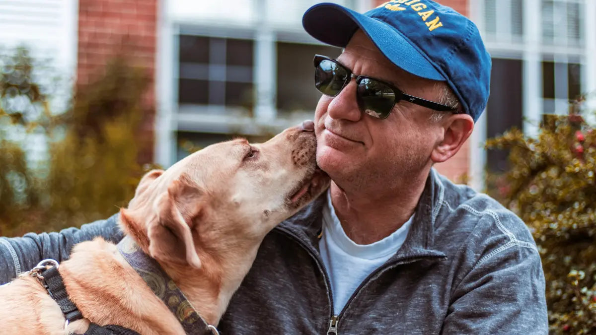 Hond geeft likje aan baasje op een zonnige dag – frisse adem en goede mondgezondheid